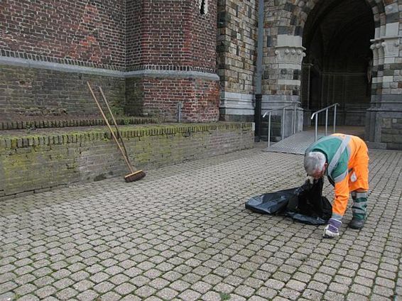 Onkruid rond de kerk wordt verwijderd - Houthalen-Helchteren