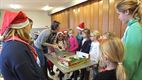Tuinhier leert kinderen Kerstbloemstukje maken