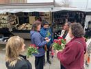 Vrouwen delen bloemen uit op de markt